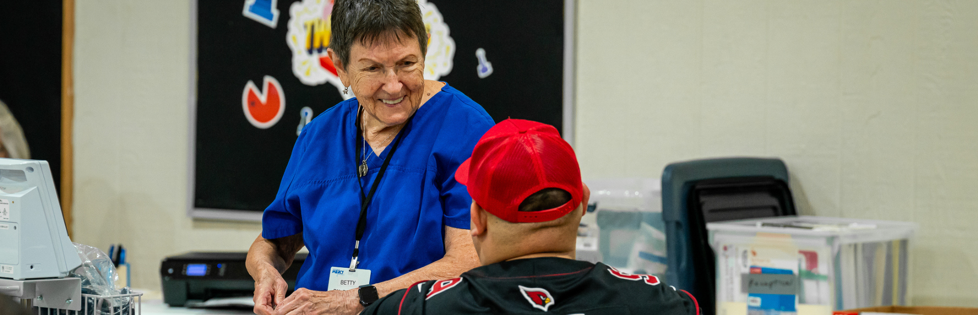 nurse treating patient with a smile showing compassion of our volunteers